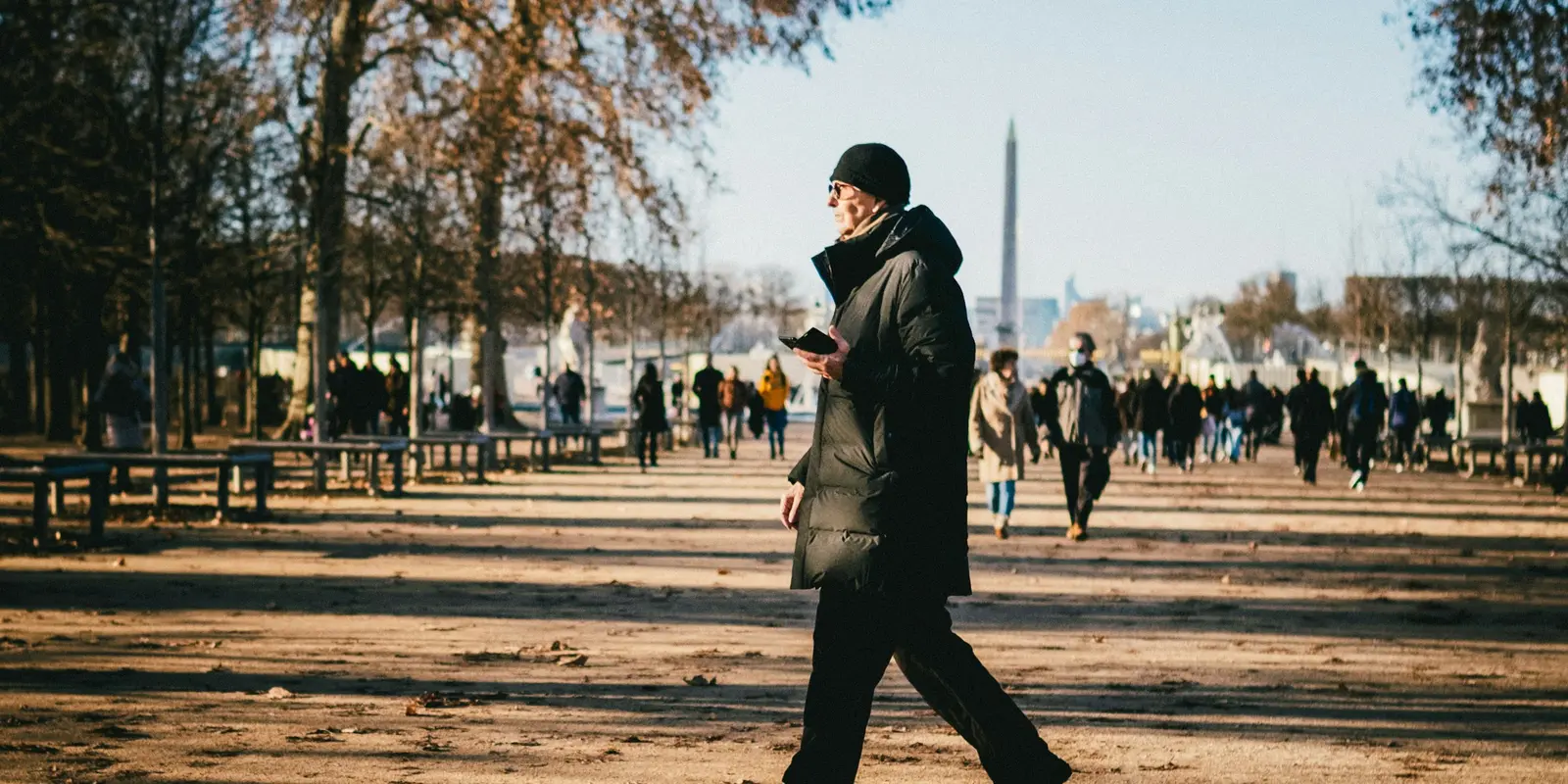 A traveler checking his phone while walking down a city street abroad