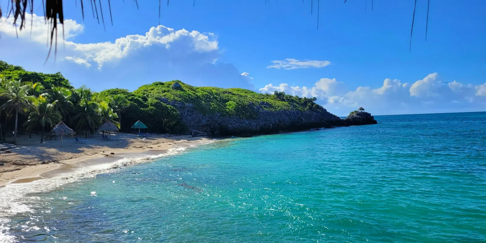 Un bote rojo sobre aguas turquesas en Paya Bay, Roatán, Honduras