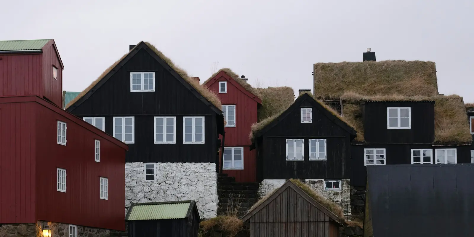 Traditional turf-roofed Faroese village houses along a fjord