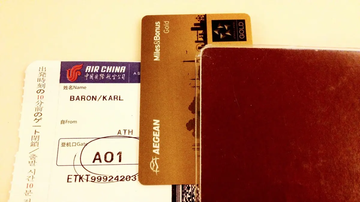A passport and paper boarding pass laid out before travel