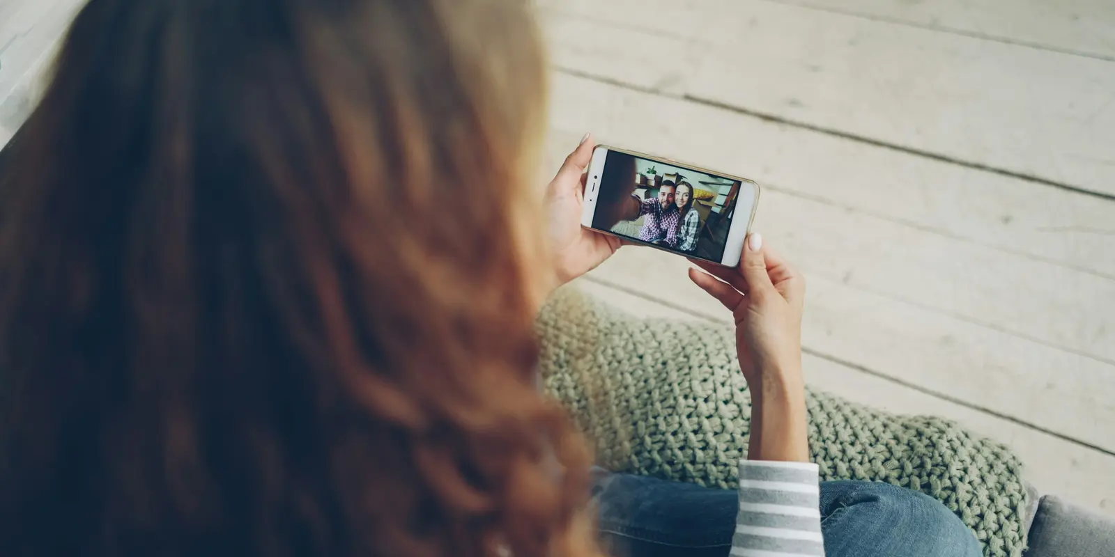 街中でスマートフォンを使ってビデオ通話をする女性——ビデオ通話はモバイルデータでもWi-Fiと同じように使える