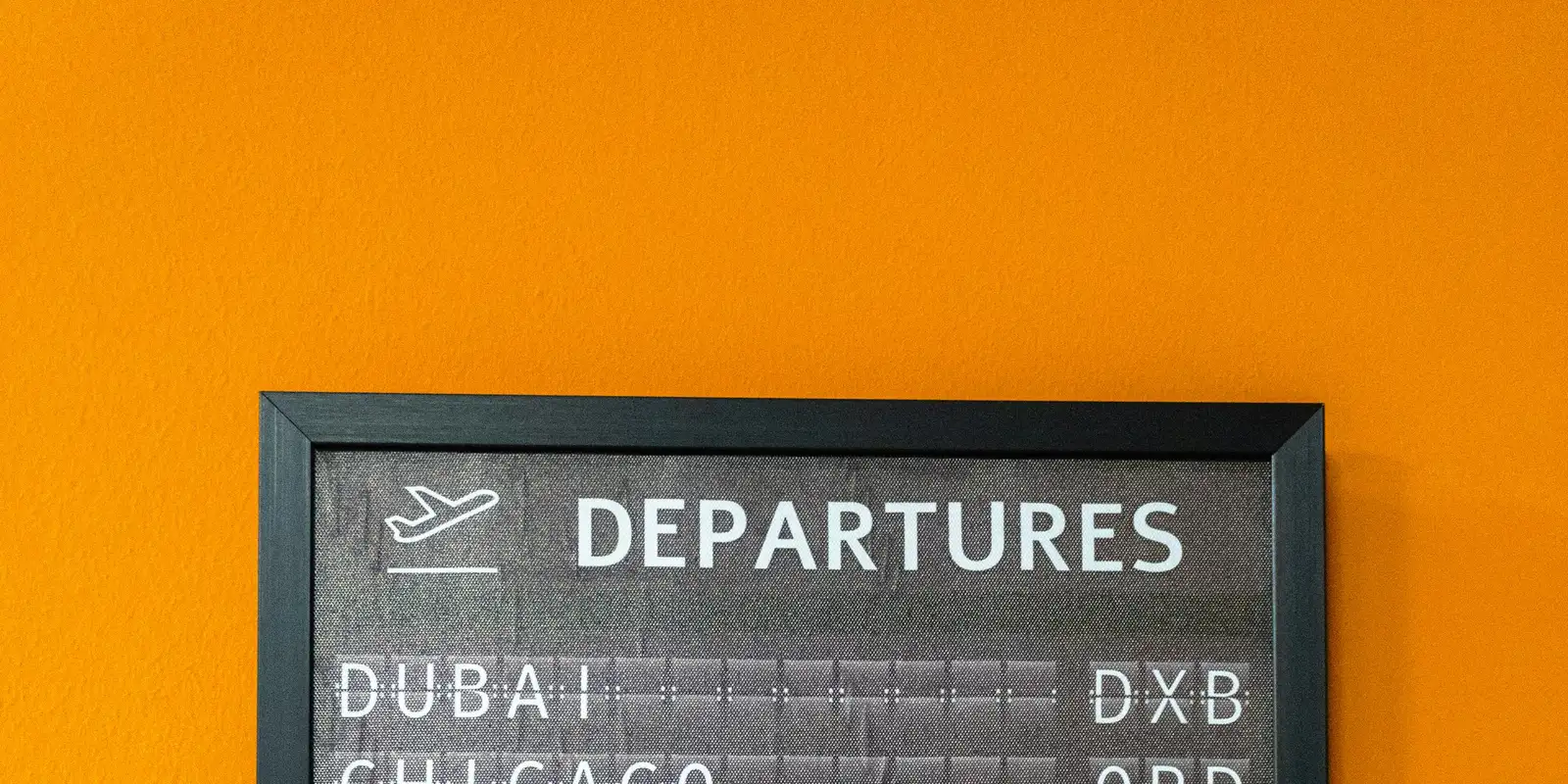 An airport departure board showing international flights
