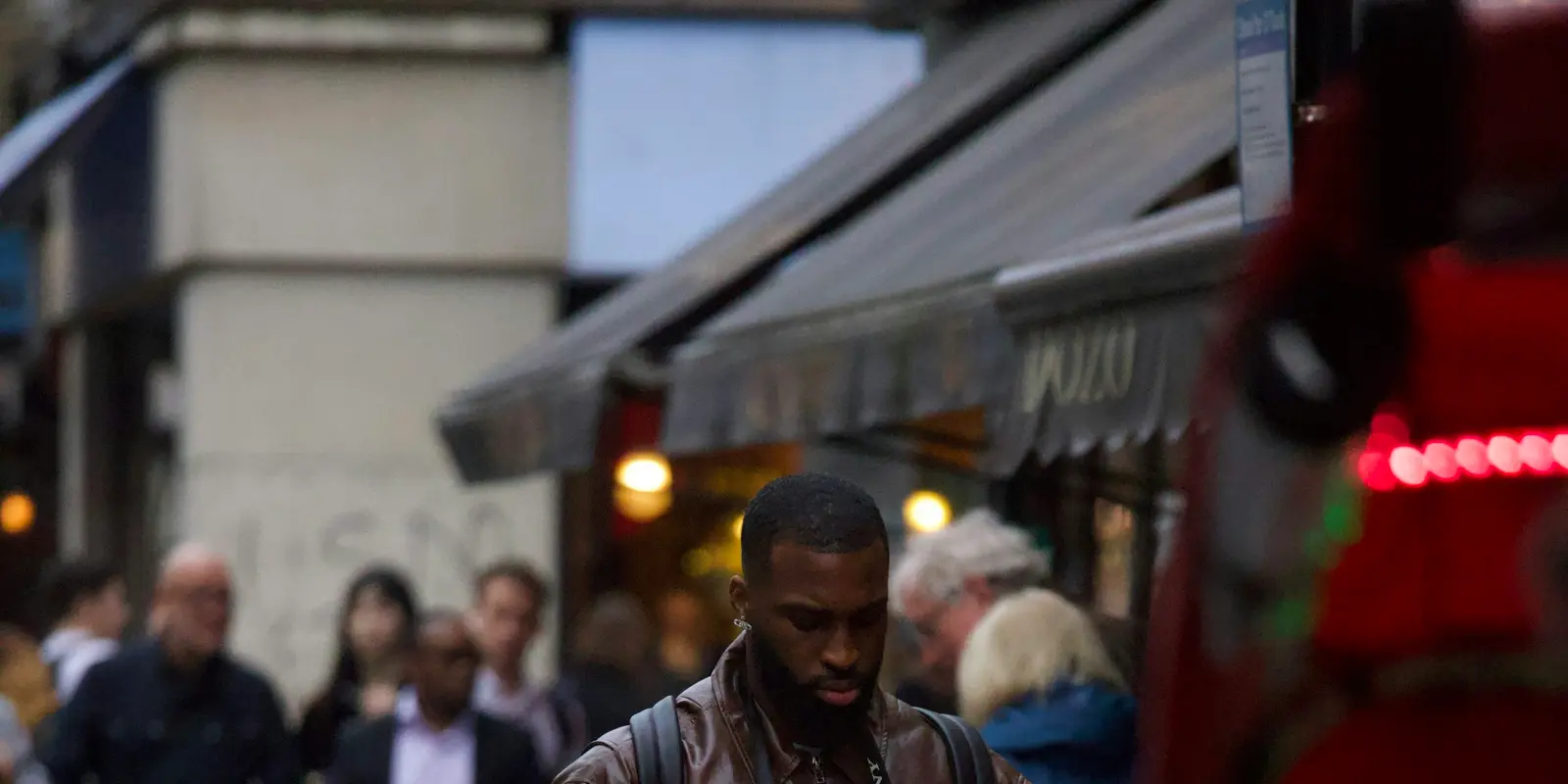 Traveler checking a smartphone while walking through a city street