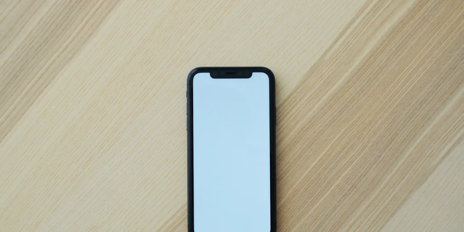 A dark screen doesn't mean a paused eSIM — the validity clock runs on the provider's network, not your device A smartphone with its screen off resting on a wooden surface
