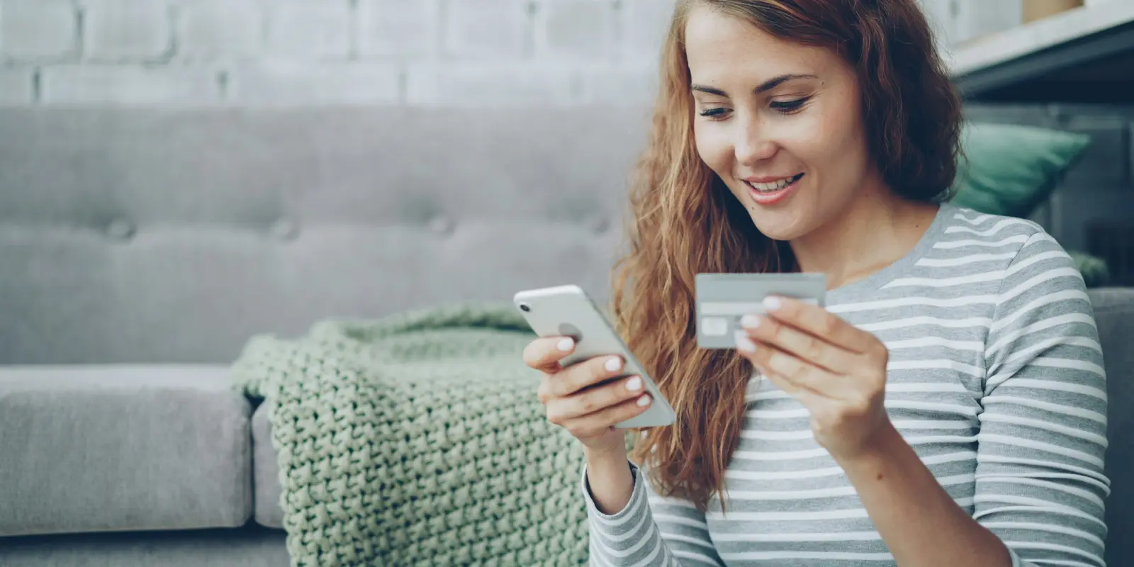 Traveler checking a credit card while paying for something on a smartphone