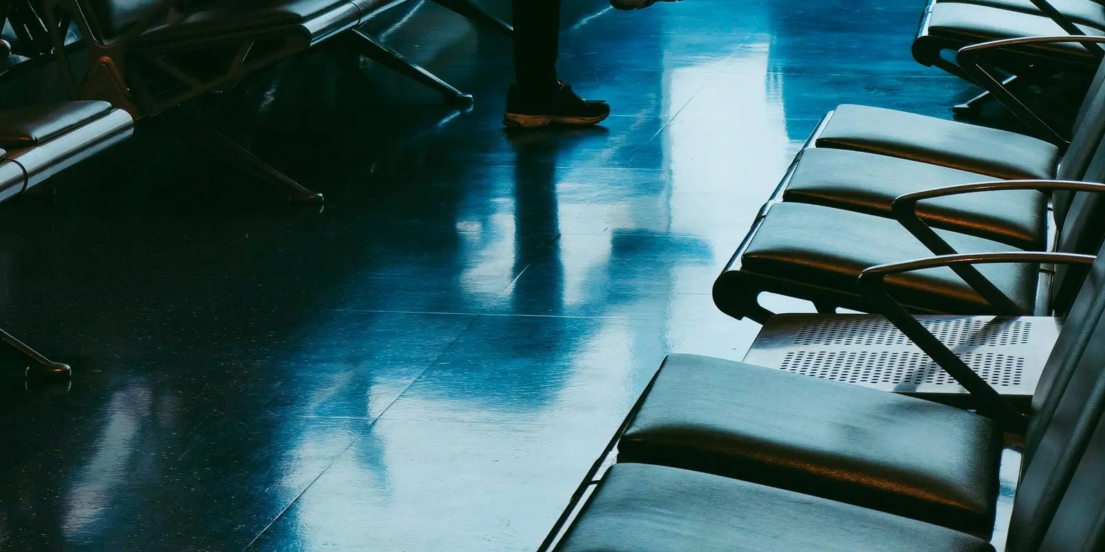 An eSIM provider's own servers, not the mobile network, are usually what actually disappears first when a company shuts down Traveler sitting in an airport waiting area checking his phone