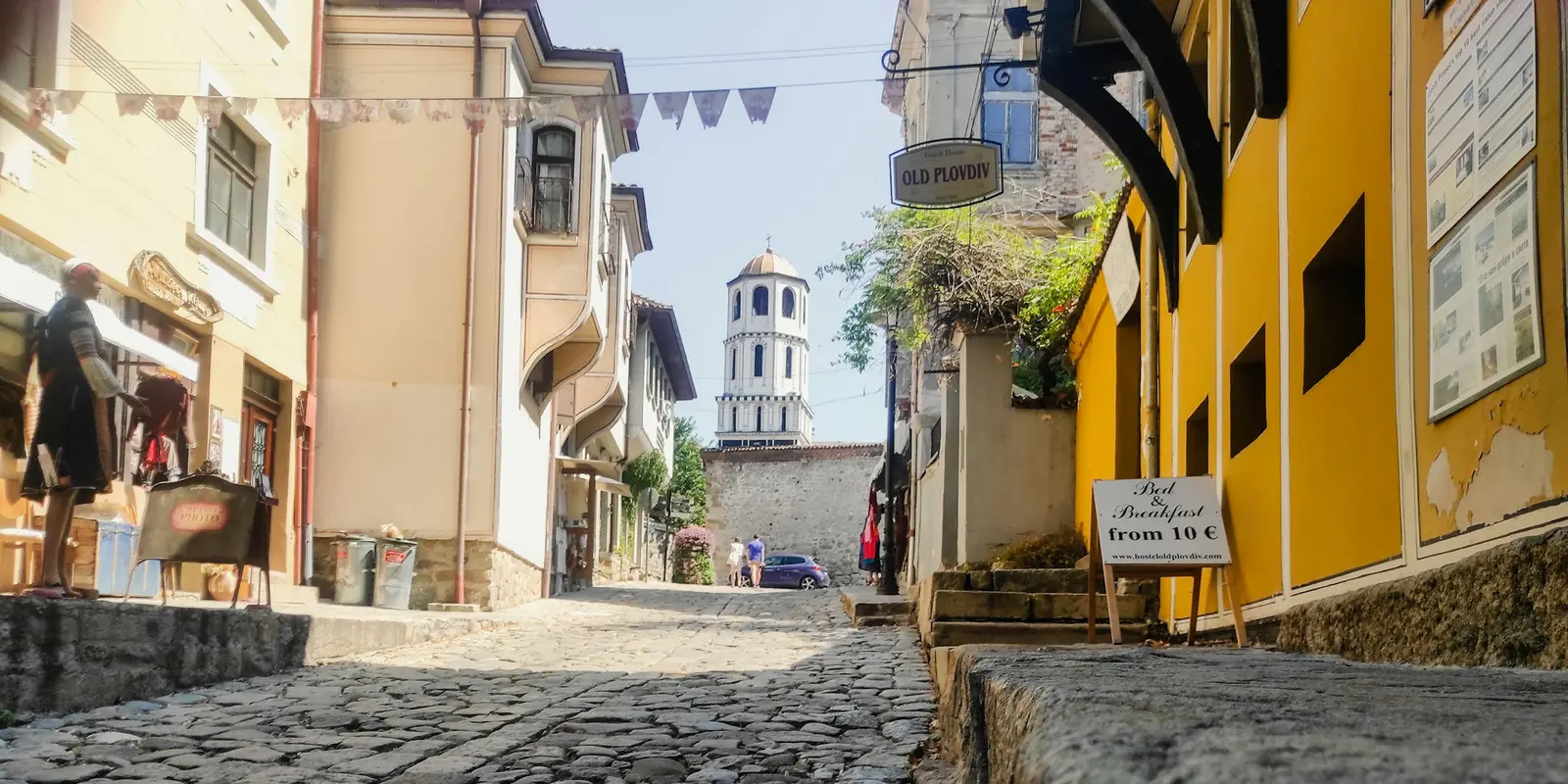 Cobblestone old-town street with a clock tower in Plovdiv, Bulgaria