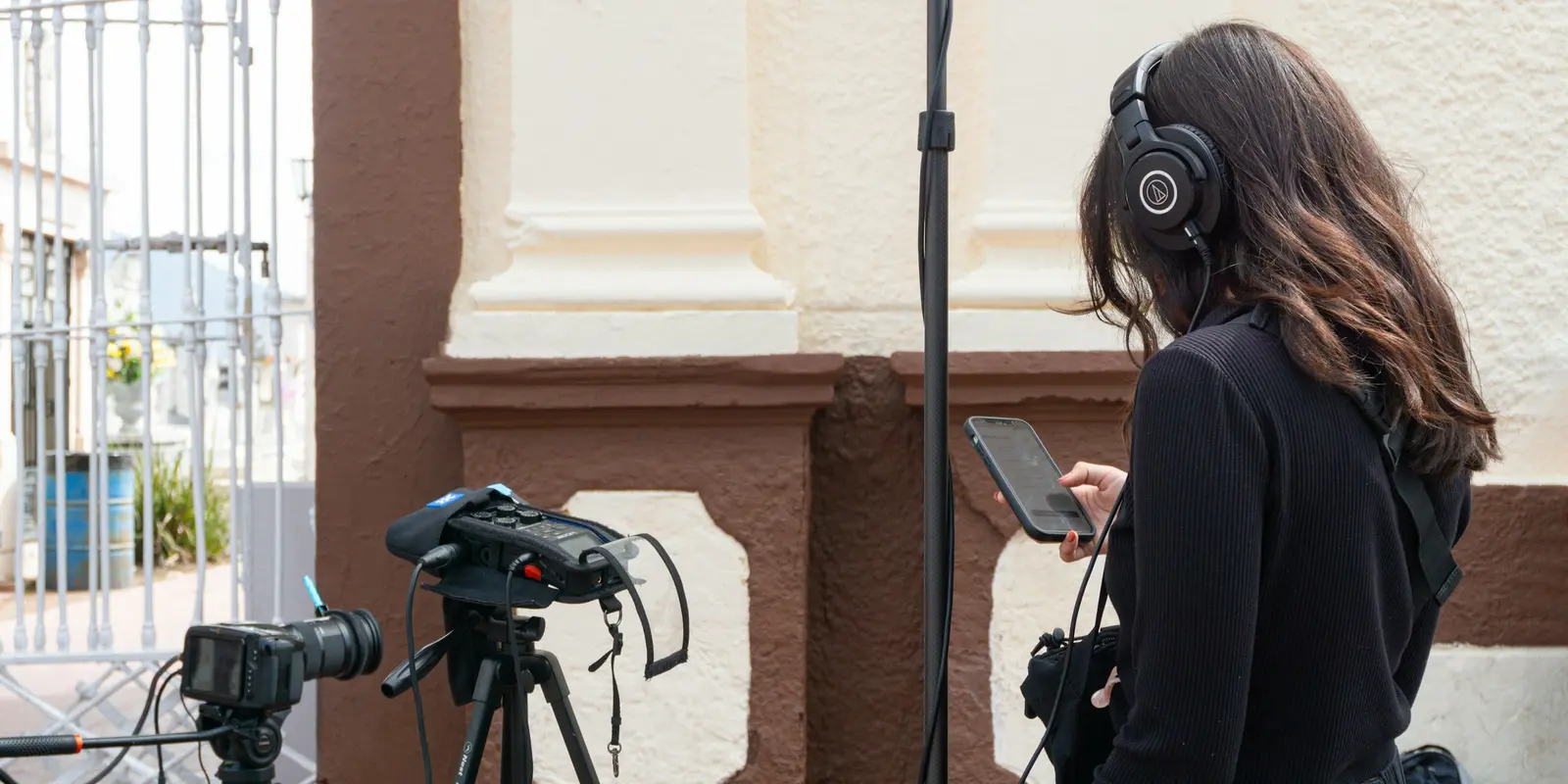 Una mujer con auriculares viendo contenido en streaming en el móvil, el tipo de uso intenso que puede activar un throttling por uso justo