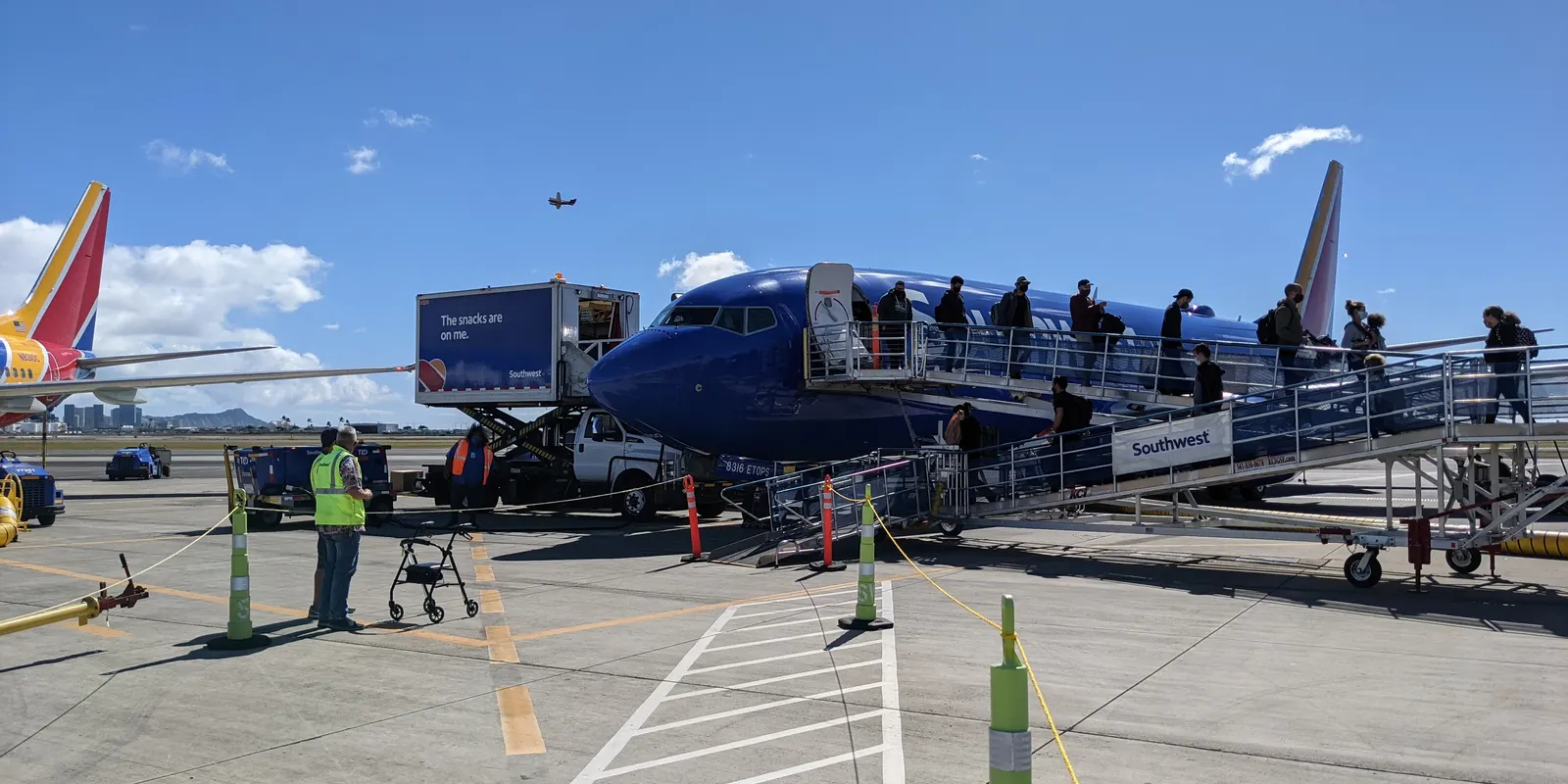 ホノルル空港で飛行機から降りる旅行者
