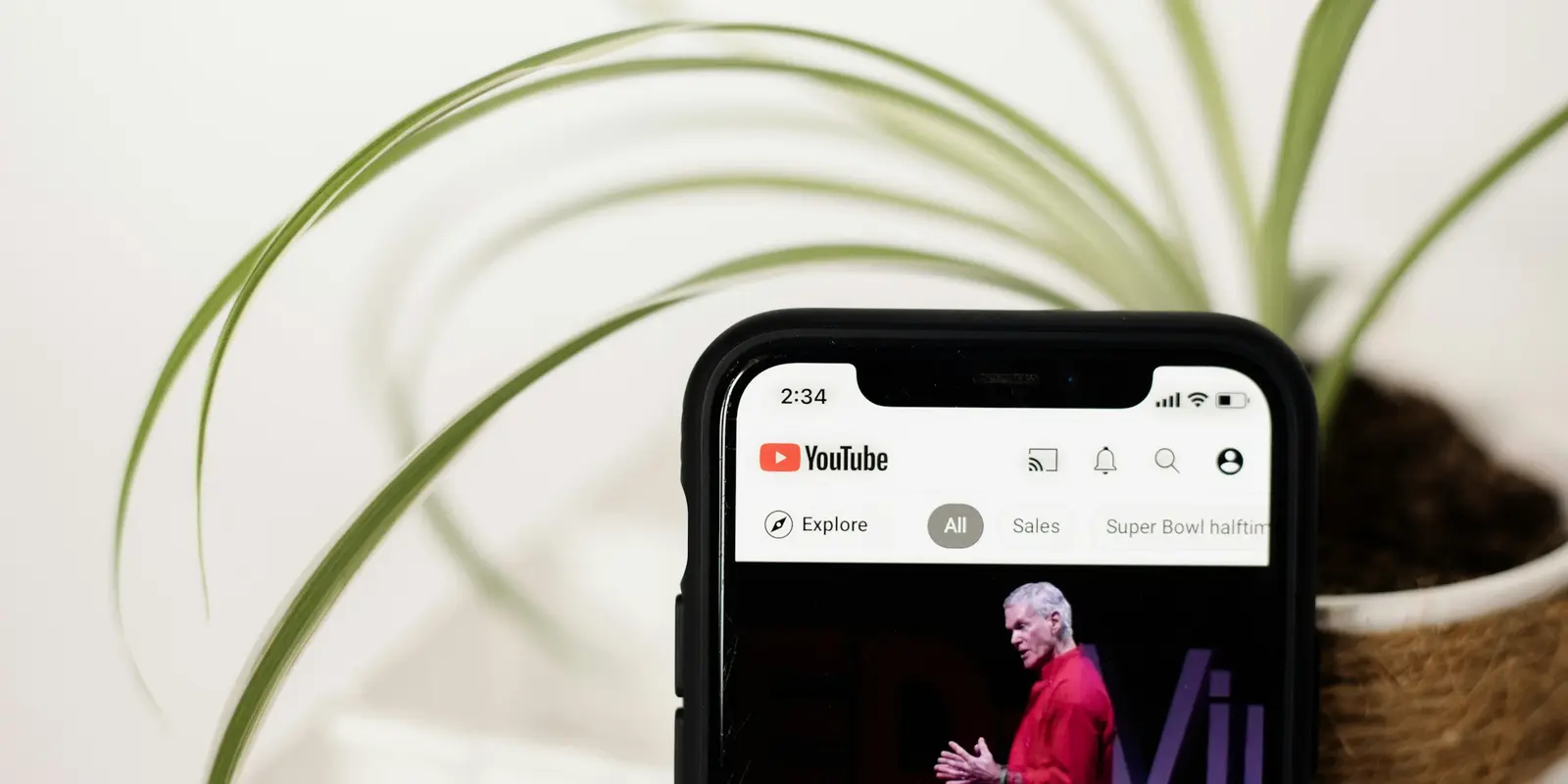 Close-up of a hand holding a phone playing a video