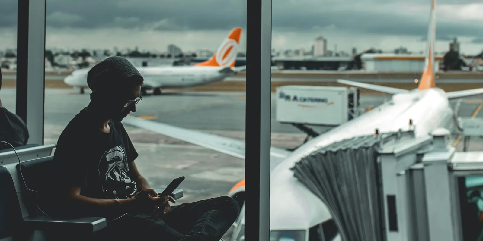 Traveler checking a phone at the airport before connecting