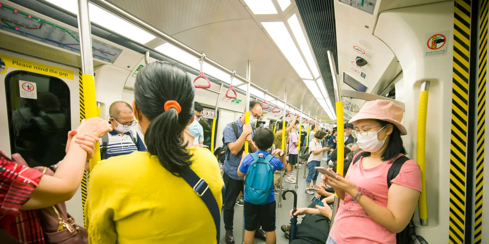 Commuters riding a Hong Kong MTR train, where 15-minute free WiFi sessions are available on every platform and concourse, capped at 10 sessions per device per day