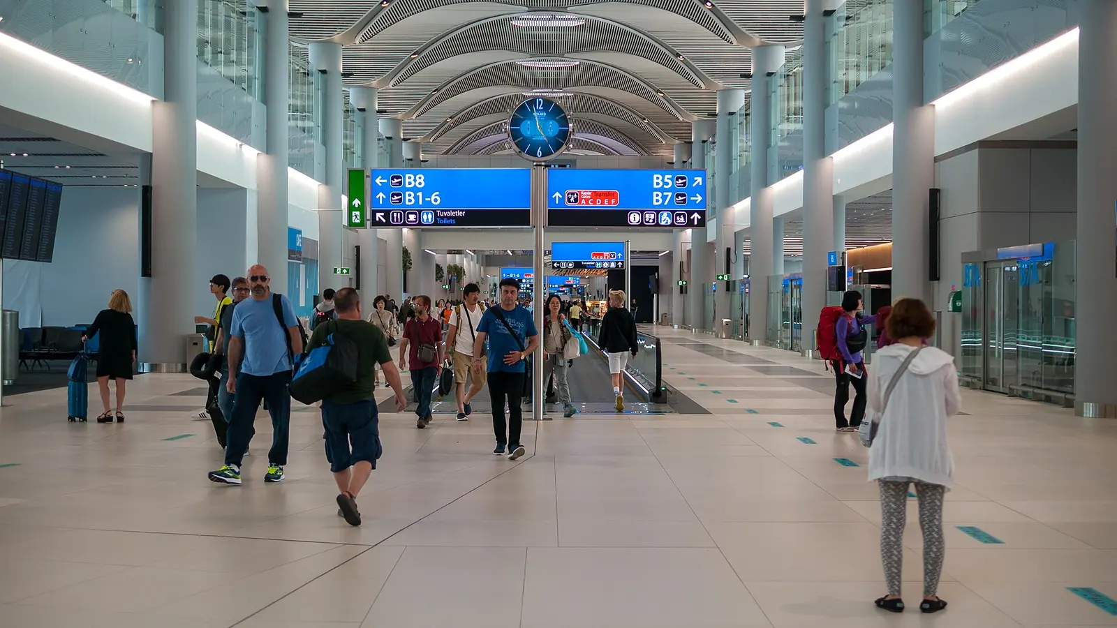 Keep the gate and transfer details accessible offline Departure concourse at Istanbul Airport with signs for gates B1 to B8