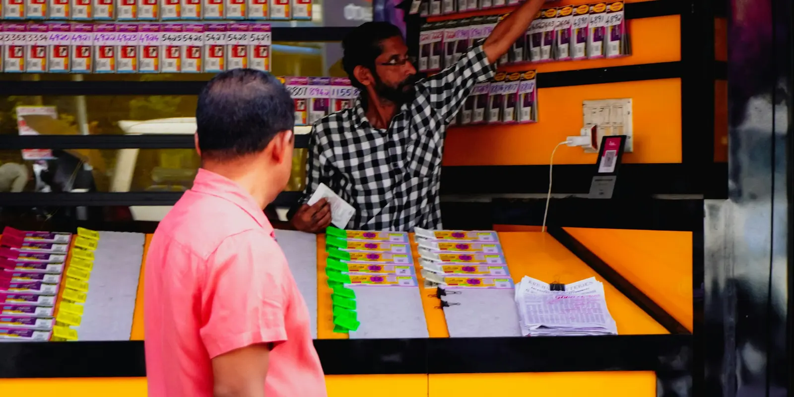 Vendedor mostrando productos a un cliente en el mostrador de una tienda de móviles