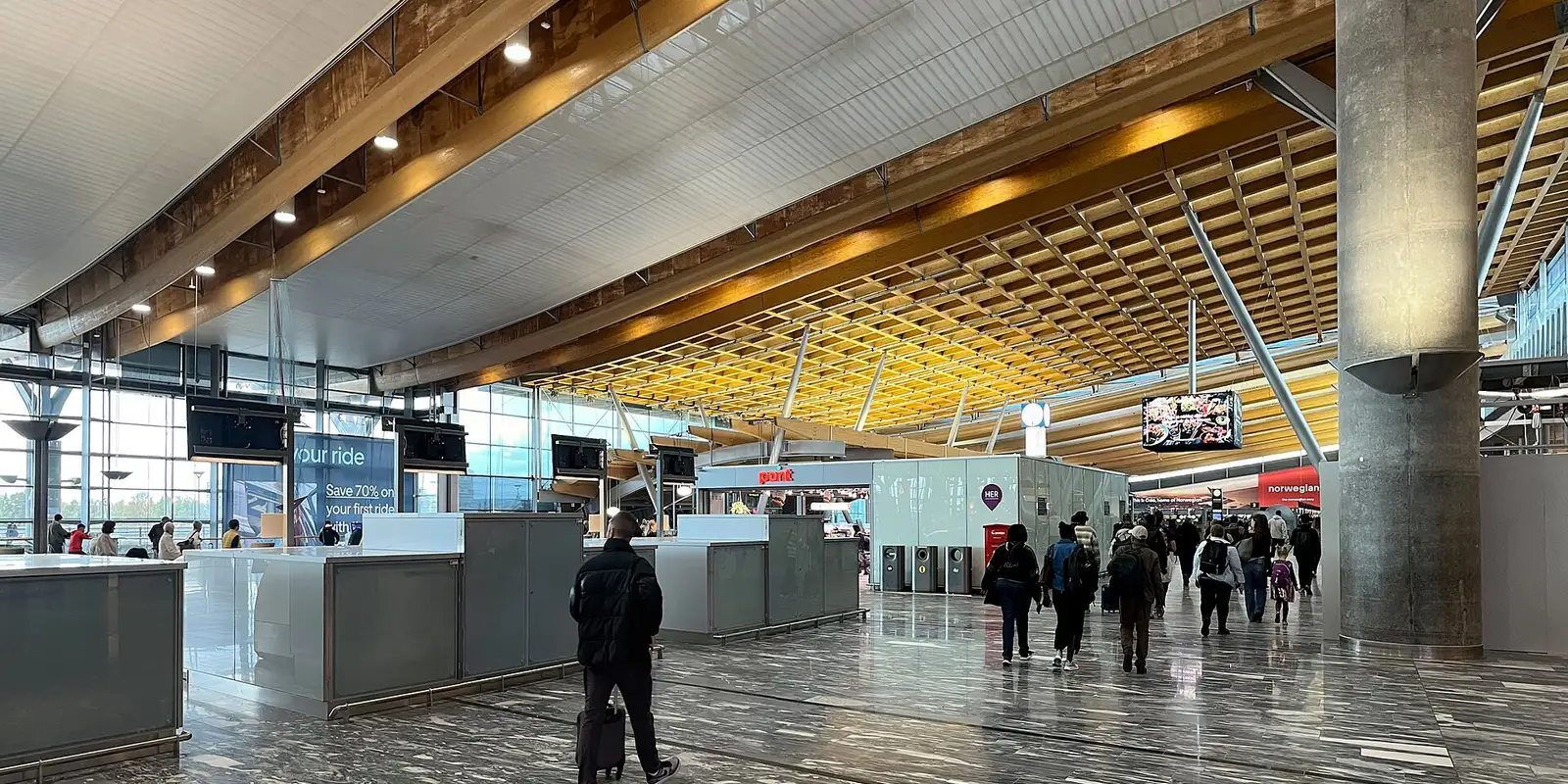 Travellers inside the Oslo Airport terminal, where Avinor's free AIRPORT Wi-Fi network is available