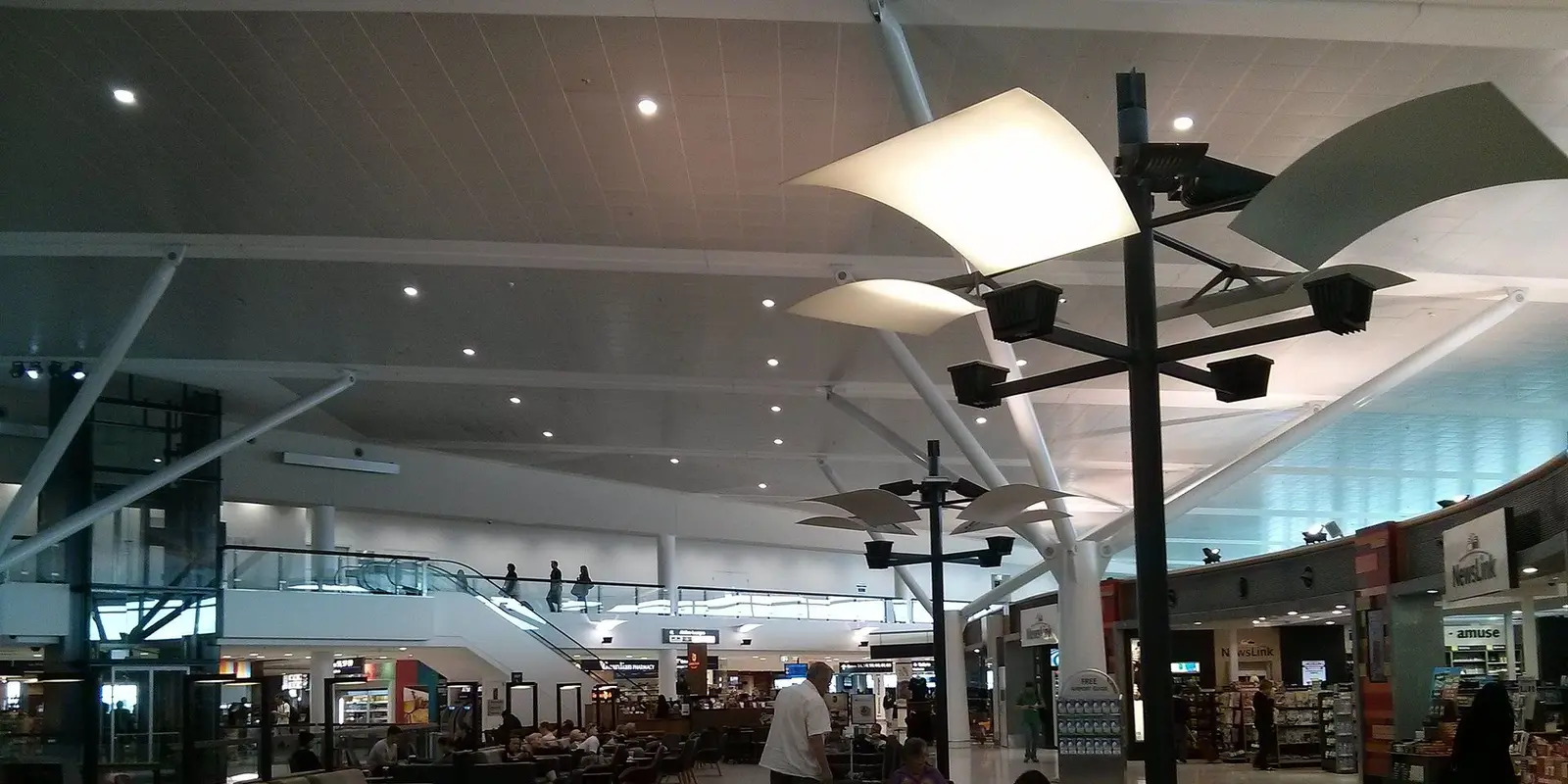 Passengers on a Sydney Airport terminal concourse where free airport Wi-Fi is available