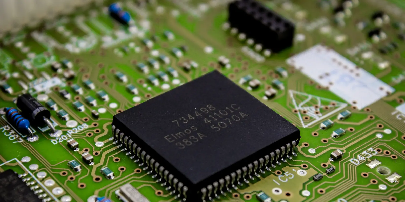 Un eUICC es un chip como este, soldado en fábrica, no una tarjeta extraíble Primer plano macro de un chip electrónico soldado a una placa de circuito